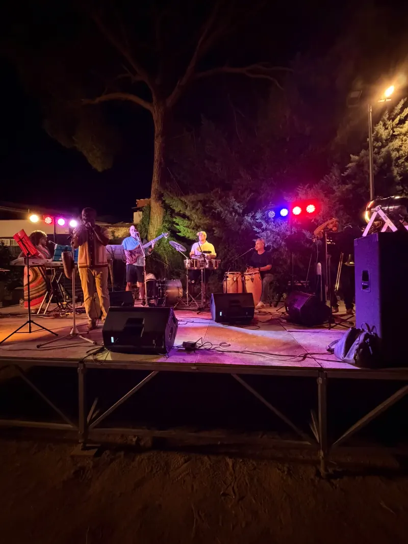 Arturito cantando con güiro al frente de la banda durante un concierto nocturno